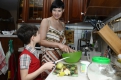 Старший из детей, семилетний Ярослав, помогает маме на кухне — режет овощи и фрукты, подает на стол.