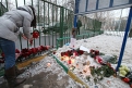 Во двор московской школы ребята несут цветы и свечи в память об учителе.