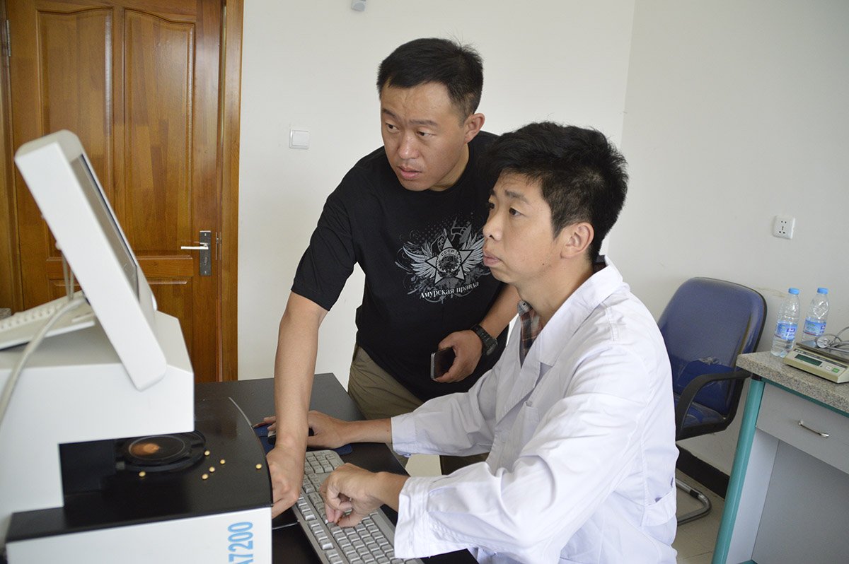 Вэй Жан и Ли Хун Пэн проводят лабораторный анализ качества сои. Фото: Андрей Анохин