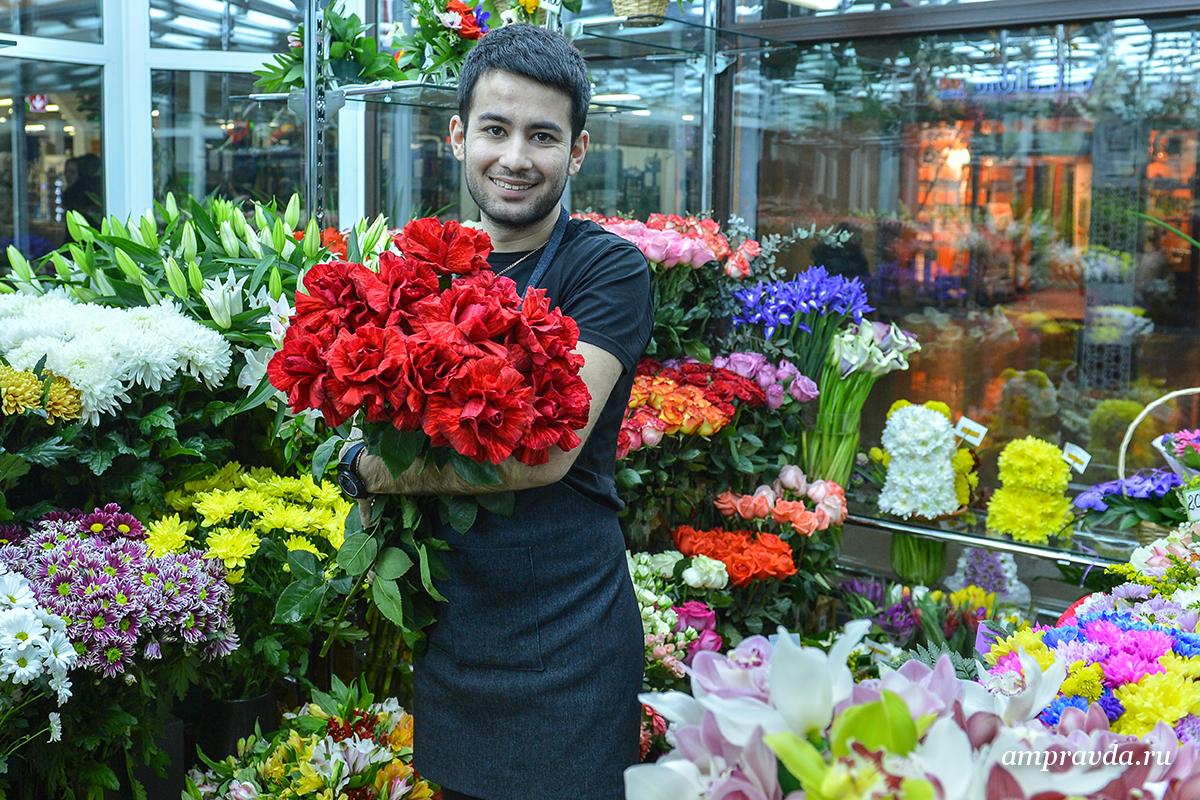 Цветочный магазин подари. Парень продает цветы. Парень в цветочном магазине. Продавец в цветочном магазине. Мужчина с цветами в магазине.